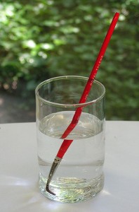 Un stylo plongé dans un verre d'eau à demi-plein paraît brisé en deux